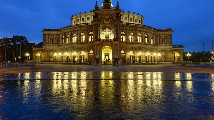 Blick am Abend auf die beleuchtete Semperoper auf dem Theaterplatz. Foto: Robert Michael/dpa-Zentralbild/dpa
