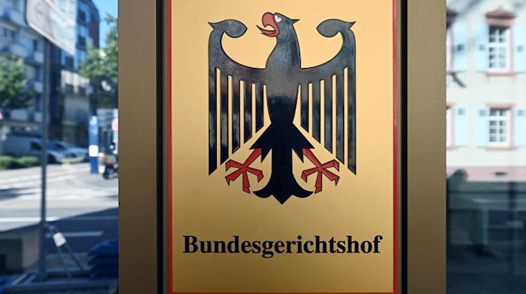 Ein Hinweisschild mit Bundesadler und Schriftzug "Bundesgerichtshof". Foto: Uli Deck/dpa/Archivbild