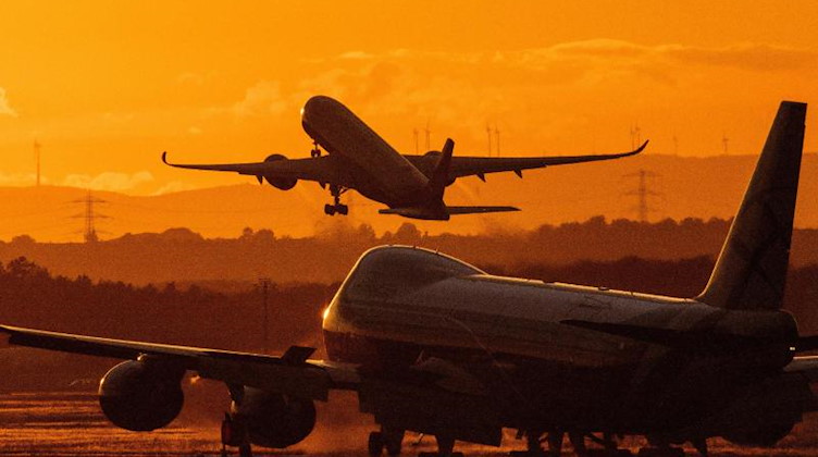 Ein Flugzeug hebt bei Sonnenuntergang von einem Flughafen ab. Foto: Boris Roessler/dpa/Symbolbild