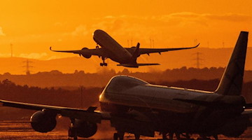 Ein Flugzeug hebt bei Sonnenuntergang von einem Flughafen ab. Foto: Boris Roessler/dpa/Symbolbild