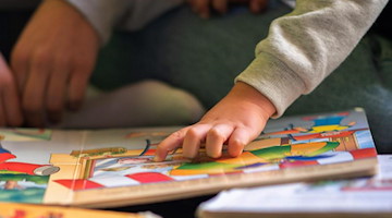 Eine Praktikantin liest in einer Kita Kindern vor. Foto: Sebastian Gollnow/dpa/Illustration