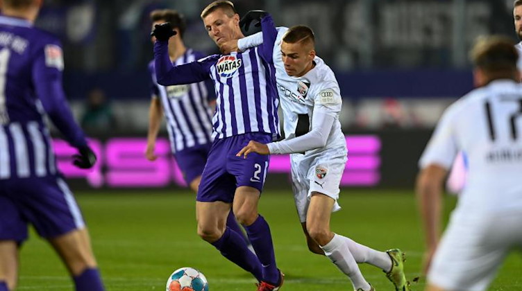 Aues Gaëtan Bussmann (l) und Ingolstadts Filip Bilbija kämpfen um den Ball. Foto: Hendrik Schmidt/dpa-Zentralbild/dpa/Archivbild