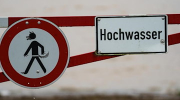 Ein Hochwasser-Schild steht an einem überfluteten Feld. Foto: Andreas Arnold/dpa/Symbolbild