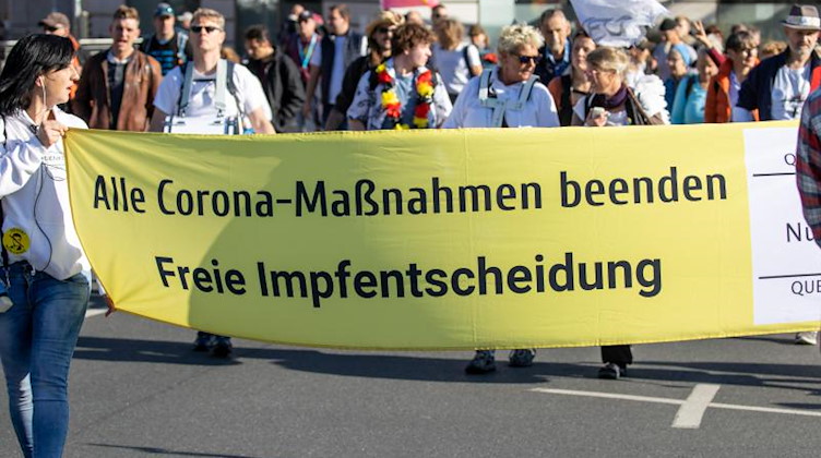 Eine Demonstration gegen Corona-Maßnahmen von vorne fotografiert. Foto: Daniel Karmann/dpa/Symbolbild