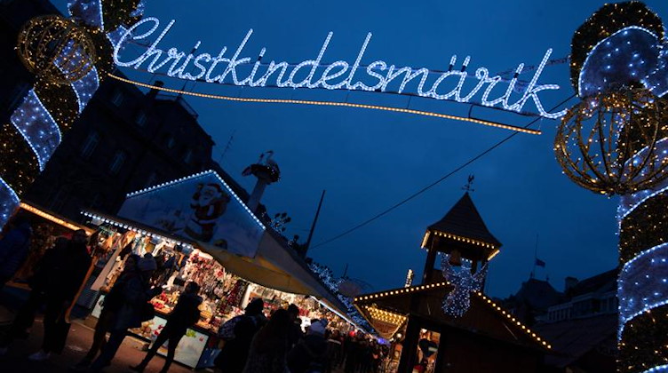 Das Wort «Christkindelsmärik» prangt in beleuchteten Buchstaben an einem Zugang zum Weihnachtsmarkt. Foto: Marijan Murat/dpa/Archiv