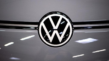 Das Logo von Volkswagen an einem Elektroauto. Foto: Sina Schuldt/dpa/Symbolbild