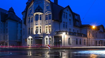 Die Lichter von vorbeifahrenden Autos sind vor dem Theater der Jungen Welt in Leipzig zu sehen. Foto: Hendrik Schmidt/dpa-Zentralbild/dpa