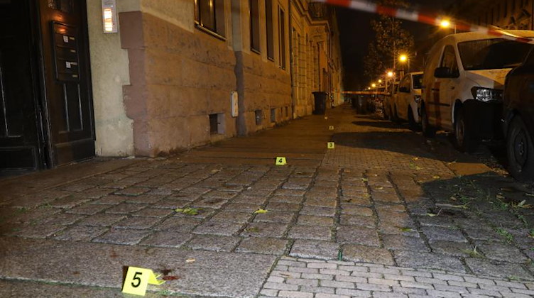 Markierungen der Spurensicherung stehen auf dem Pflaster am Tatort in Stadtteil Pieschen. Foto: -/--/dpa