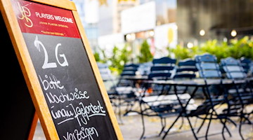 Ein Schild auf der Terrasse eines Restaurants weist auf die geltende 2G-Regel hin. Foto: Moritz Frankenberg/dpa/Symbolbild