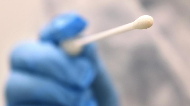Ein Arzt hält einen Tupfer, mit dem ein Abstrich für einen Coronatest gemacht wird. Foto: Karl-Josef Hildenbrand/dpa/Symbolbild