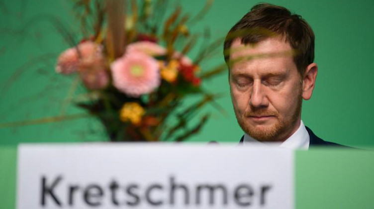 Michael Kretschmer (CDU) sitzt auf dem Landesparteitag der CDU Sachsen nach seiner Wiederwahl hinter seinem Blumenstrauß. Foto: Robert Michael/dpa-Zentralbild/dpa