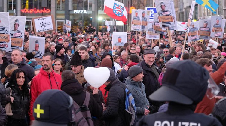 Teilnehmer einer Kundgebung von Kritikern der Coronamaßnahmen der Bundesregierung stehen auf dem Augustusplatz der Polizei gegenüber. Foto: Sebastian Willnow/dpa-Zentralbild/dpa