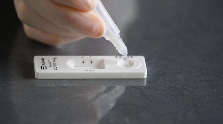 Eine Lösung wird auf eine Testkassette eines Corona-Schnelltests aufgeträufelt. Foto: Robert Michael/dpa-Zentralbild/dpa/Symbolbild