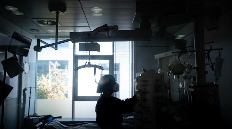 Eine Mitarbeiterin der Pflege steht in einem Zimmer einer Corona-Intensivstation. Foto: Fabian Strauch/dpa/Illustration