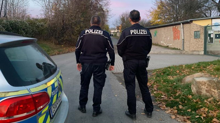 Zwei Polizisten stehen in der Nähe des Fundortes der toten 14-Jährigen. Foto: Thomas Schulz/dpa-Zentralbild/dpa