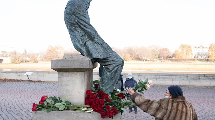 Eine Frau legt Blumen am Denkmal Fjodor Dostojewski in Dresden nieder. Foto: Sebastian Kahnert/dpa-Zentralbild/dpa