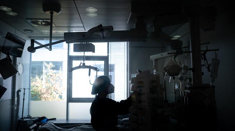 Eine Mitarbeiterin der Pflege steht in einem Zimmer einer Corona-Intensivstation. Foto: Fabian Strauch/dpa/Illustration