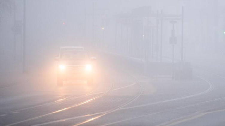 Autos fahren bei dichtem Nebel über eine Straße. Foto: Julian Stratenschulte/dpa/Symbolbild