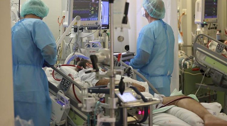 Zwei Intensivpfleger versorgen einen Covid-19-Patienten auf der Intensivstation der Leipziger Uniklinik. Foto: Jan Woitas/dpa-Zentralbild/dpa