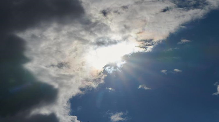 Die Sonne kommt hinter Regenwolken hervor. Foto: Annette Riedl/dpa/Symbolbild