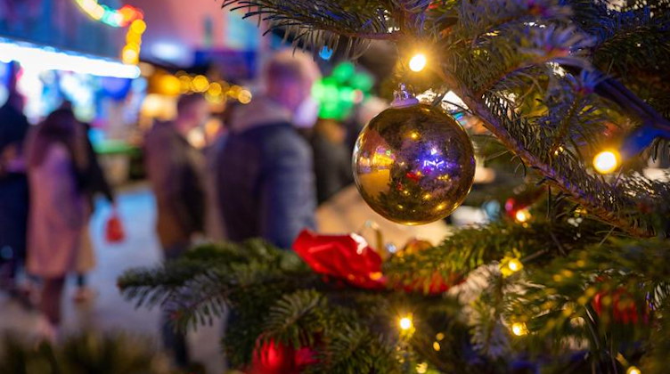 Ein festlich geschmückter Baum steht auf einem Weihnachtsmarkt. Foto: Monika Skolimowska/dpa-Zentralbild/ZB/Symbolbild