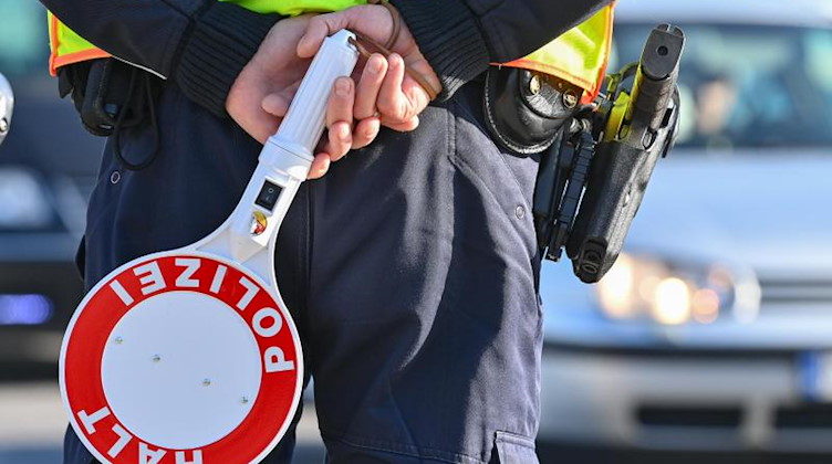Ein Polizeibeamter hält eine Winkerkelle in den Händen. Foto: Patrick Pleul/dpa-Zentralbild/ZB/Symbolbild