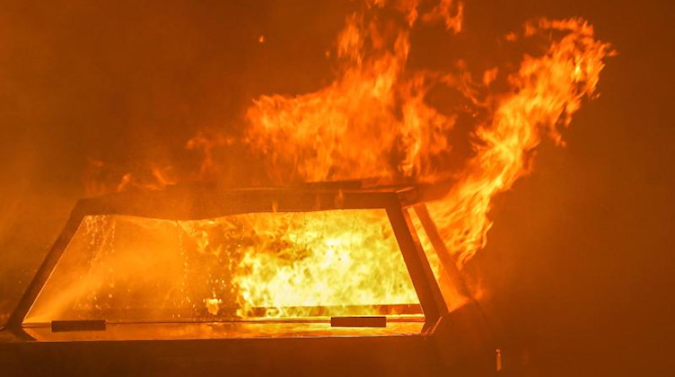 Ein Auto steht in Flammen. Foto: David Young/dpa/Symbolbild