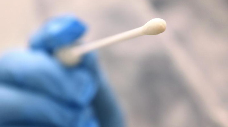 Ein Arzt hält einen Tupfer, mit dem ein Abstrich für einen Coronatest gemacht wird. Foto: Karl-Josef Hildenbrand/dpa/Symbolbild