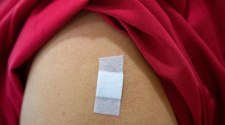 Einer Mitarbeiterin in einem Pflegeheim klebt nach einer Corona-Impfung ein Pflaster auf dem Arm. Foto: Sebastian Gollnow/dpa/Symbolbild