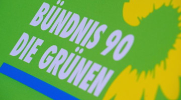 Das Logo von Bündnis 90/Die Grünen steht auf einem Aufsteller der Partei. Foto: Stefan Sauer/zb/dpa/Archivbild