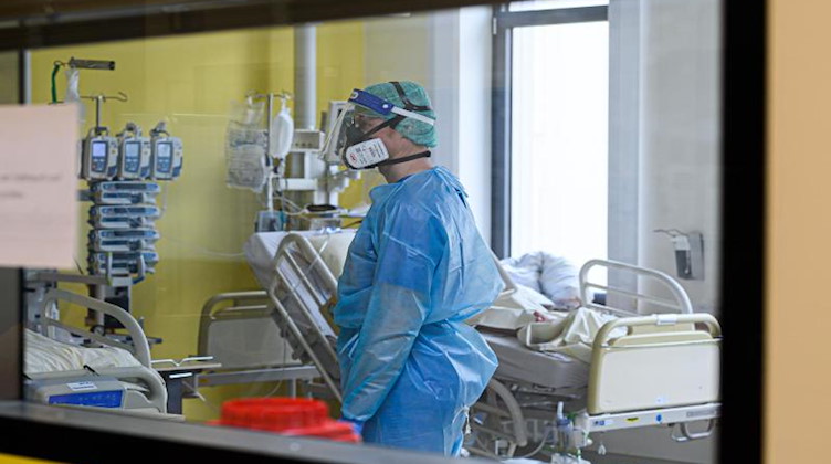Ein Pfleger versorgt auf einer Covid-19-Intensivstation Corona-Patienten. Foto: Robert Michael/dpa-Zentralbild/dpa/Symbolbild