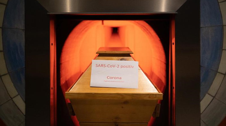 Ein Verstorbener in einem Sarg mit Aufschrift „SARS-CoV-2 positiv - Corona“ wird eingeäschert. Foto: Julian Stratenschulte/dpa/Symbolbild