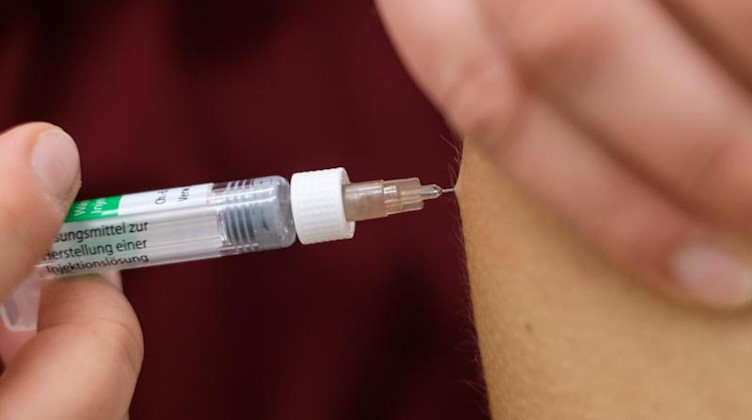 Eine Arzthelferin impft eine Patentin mit einer Spritze. Foto: Ole Spata/dpa/Symbolbild