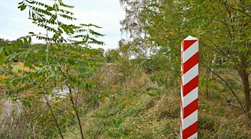 Ein Grenzpfeiler in den Nationalfarben Polens steht am Ufer des Flusses Neiße. Foto: Patrick Pleul/dpa-Zentralbild/dpa/Archivbild
