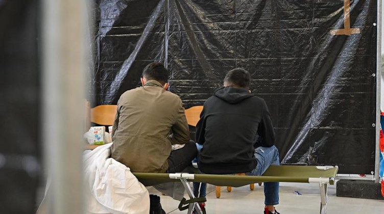 Migranten sitzen in der zentralen Bearbeitungstelle für Migration und Flüchtlinge (BAMF). Foto: Patrick Pleul/dpa-Zentralbild/dpa/Archivbild