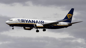 Eine Passagiermaschine von Ryanair setzt vor dunklen Wolken zum Landeanflug an. Foto: Boris Roessler/dpa/Symbolbild