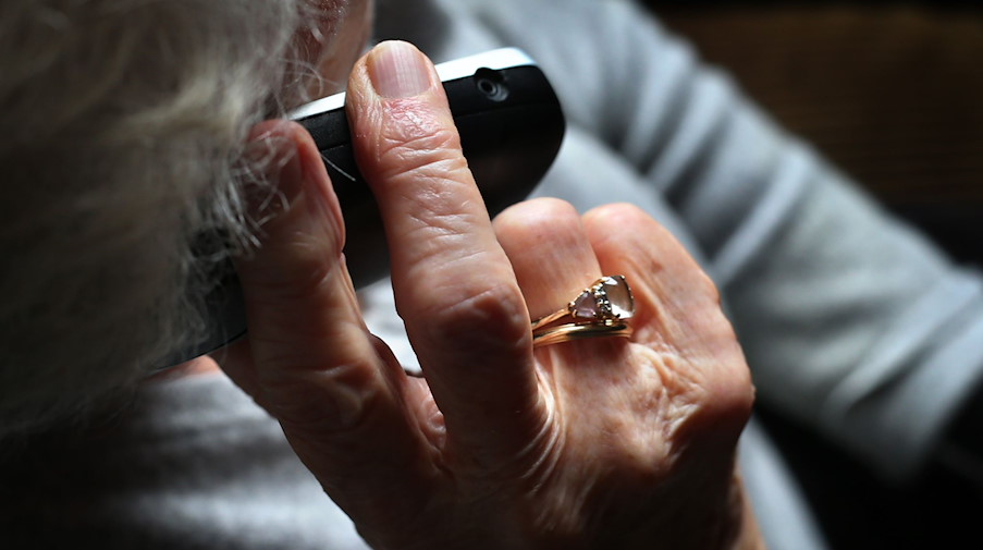Eine Rentnerin hält ein Telefon in der Hand. / Foto: Karl-Josef Hildenbrand/dpa/Symbolbild