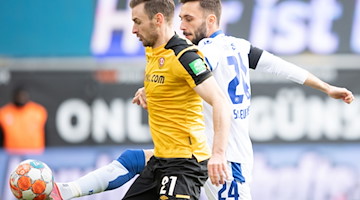 Dynamos Michael Sollbauer (l) wird vom Karlsruher Fabian Schleusener der Ball abgenommen. / Foto: Sebastian Kahnert/dpa-Zentralbild/dpa