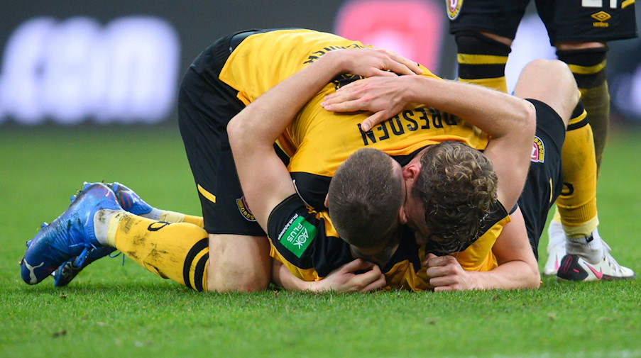 Dynamos Christoph Daferner und Kevin Ehlers umarmen sich am Boden. / Foto: Robert Michael/dpa-Zentralbild/dpa/Bildarchiv