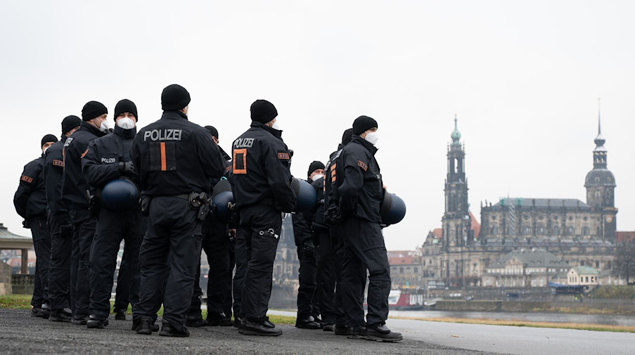 Polizisten stehen am Ufer der Elbe vor der Kulisse der Altstadt. / Foto: Sebastian Kahnert/dpa-Zentralbild/dpa/Archivbild