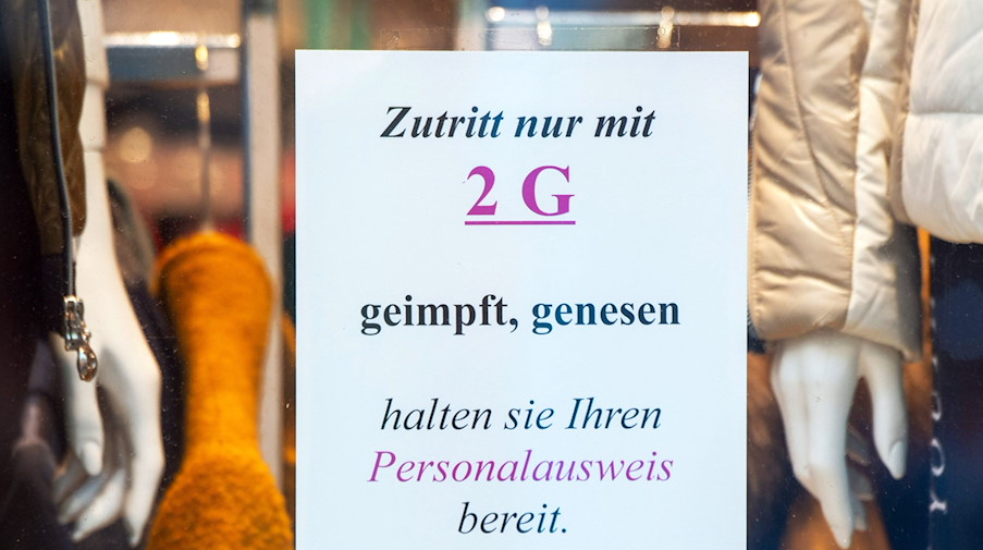 «Zutritt nur mit 2 G» steht auf dem Schild am Eingang eines Bekleidungsgeschäfts. / Foto: Stefan Sauer/dpa/Symbolbild