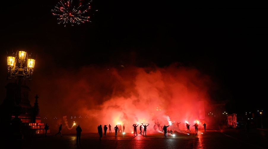 Dynamo-Fans feiern auf dem Theaterplatz vor der Semperoper mit Bengalos die Ankunft der Mannschaft. / Foto: Robert Michael/dpa-Zentralbild/dpa