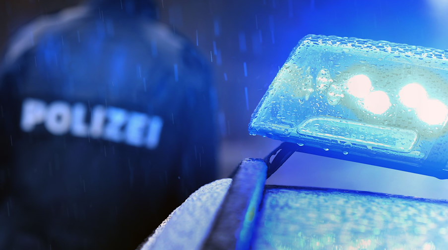 Ein Polizist steht vor einem Streifenwagen mit Blaulicht. / Foto: Karl-Josef Hildenbrand/dpa/Symbolbild