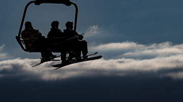 Wintersportler sitzen im Sessellift «Hexenritt-Express». / Foto: Swen Pförtner/dpa