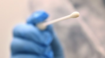 Ein Arzt hält einen Tupfer, mit dem ein Abstrich für einen Coronatest gemacht wird. / Foto: Karl-Josef Hildenbrand/dpa/Symbolbild