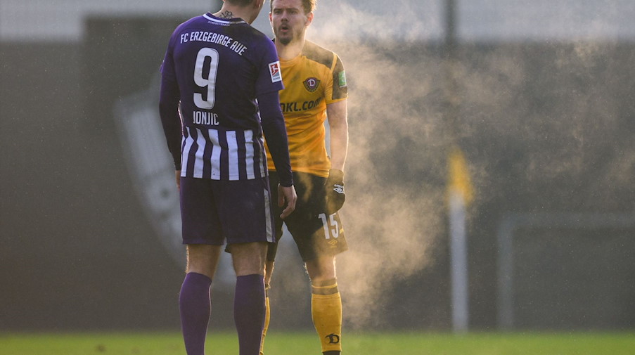 Dynamos Chris Löwe (r) spricht dampfend mit Aues Antonio Jonjic. / Foto: Robert Michael/dpa-Zentralbild/ZB