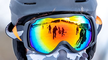 Der Skihang spiegelt sich in der Skibrille eines Snowboarders. / Foto: Jens Büttner/dpa-Zentralbild/dpa/Archivbild