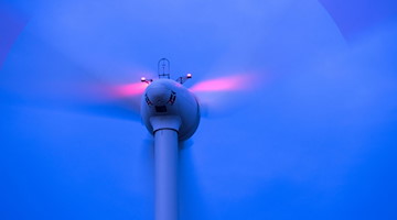 Eine Windkraftanlage dreht sich in einem Windpark. / Foto: Jens Büttner/dpa/Symbolbild