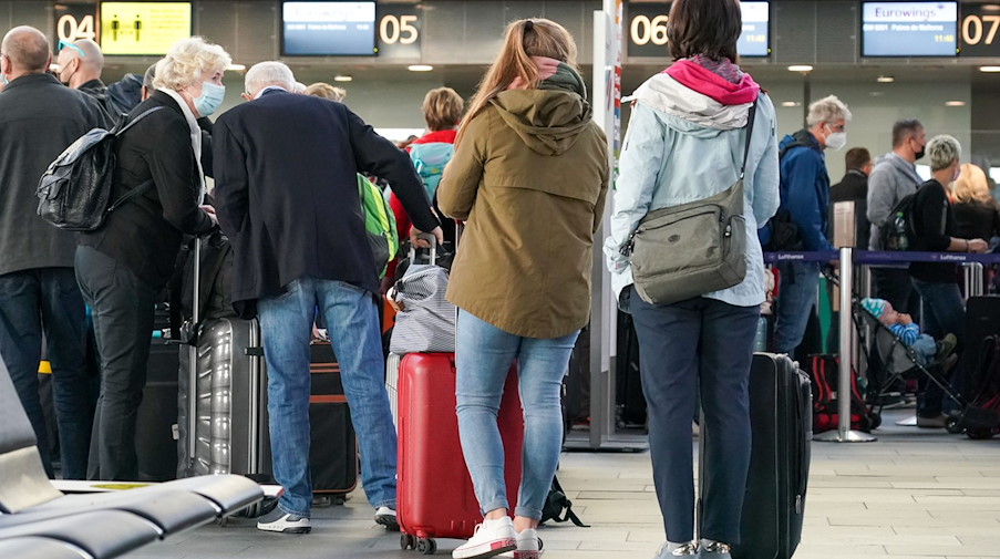 Reisende warten mit Gepäck am Check-in am Flughafen Leipzig/Halle. / Foto: Peter Endig/dpa-Zentralbild/dpa/Archivbild