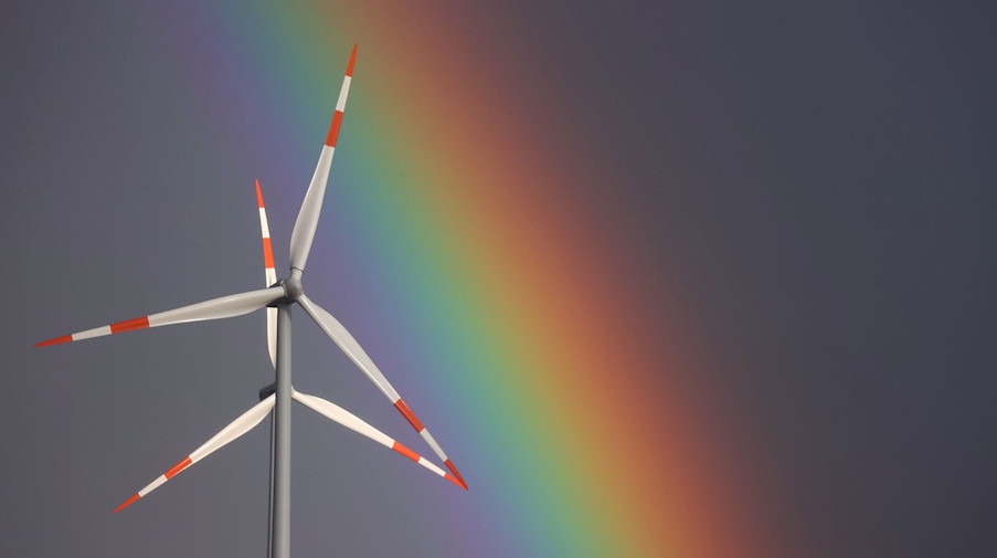 Zwei Windräder drehen sich bei heftigem Wind vor einem Regenbogen. / Foto: Karl-Josef Hildenbrand/dpa/Symbolbild
